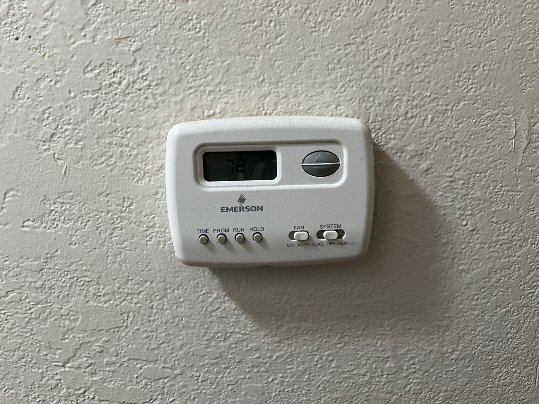 Before picture of thermostat inside unit of Huron Plaza Apartments